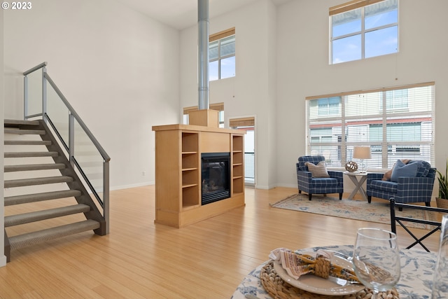 living room with a healthy amount of sunlight, wood-type flooring, and a high ceiling