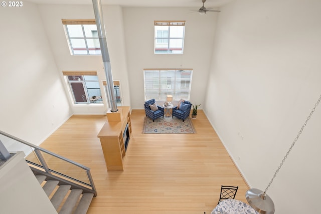 interior space featuring a towering ceiling, light hardwood / wood-style floors, and ceiling fan