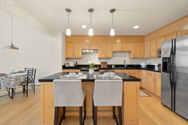 kitchen with a kitchen island, decorative light fixtures, light hardwood / wood-style flooring, stainless steel refrigerator with ice dispenser, and light brown cabinetry