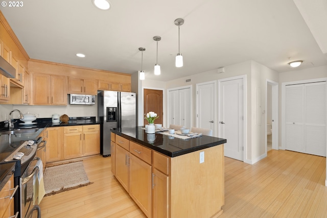 kitchen featuring pendant lighting, stainless steel appliances, a center island, light hardwood / wood-style flooring, and sink