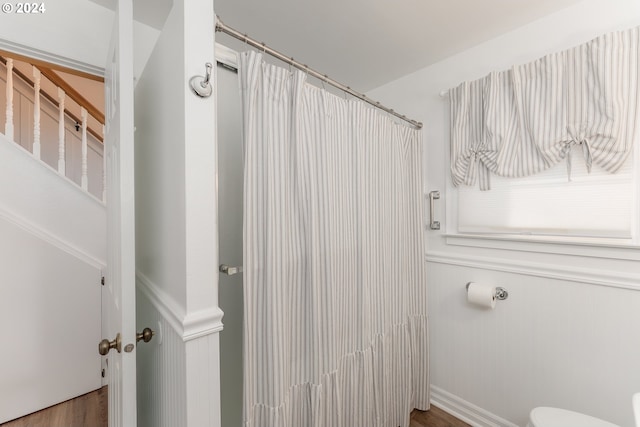 bathroom with a shower with curtain, hardwood / wood-style flooring, and toilet