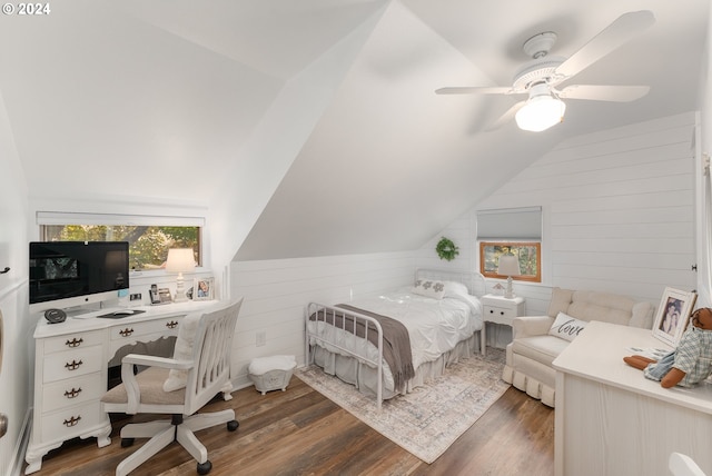 bedroom featuring lofted ceiling, dark hardwood / wood-style floors, wood walls, and ceiling fan