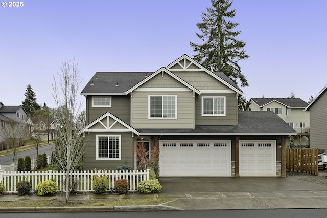 craftsman inspired home featuring concrete driveway and a fenced front yard