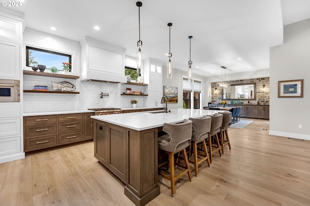 kitchen featuring a healthy amount of sunlight, a kitchen bar, decorative light fixtures, and white cabinets