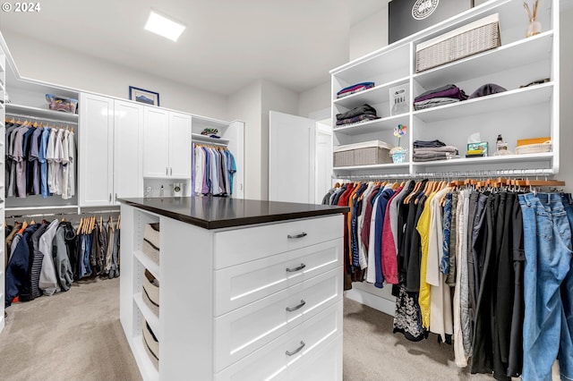 walk in closet featuring light colored carpet