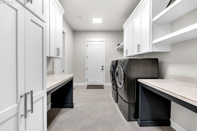 washroom featuring cabinets and washing machine and clothes dryer