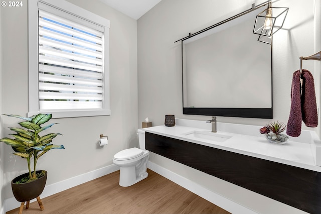 bathroom featuring vanity, toilet, hardwood / wood-style floors, and plenty of natural light