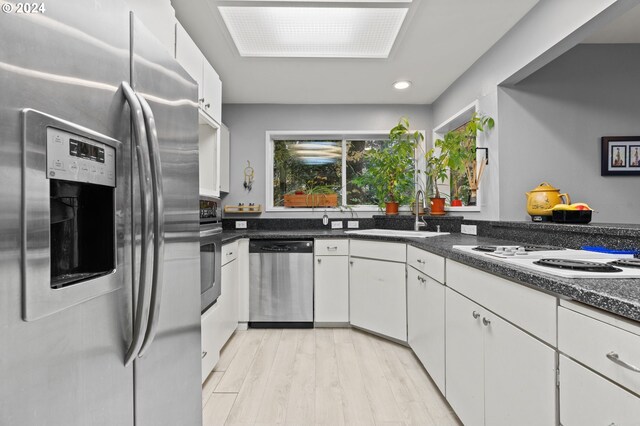 kitchen featuring light hardwood / wood-style floors, white cabinetry, sink, and appliances with stainless steel finishes