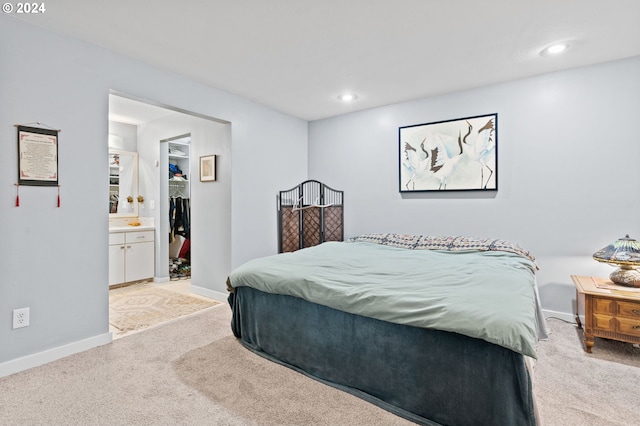 bedroom featuring ensuite bathroom and light carpet