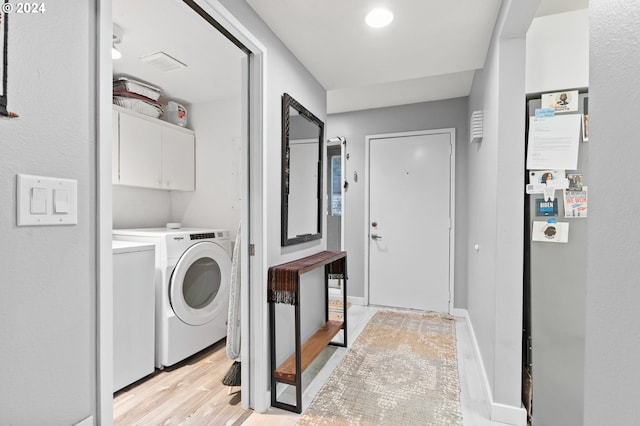 laundry room with cabinets, independent washer and dryer, and light hardwood / wood-style flooring