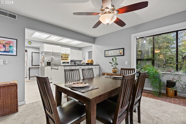 carpeted dining space featuring ceiling fan