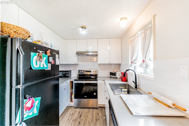 kitchen with white cabinetry, a textured ceiling, black appliances, sink, and light hardwood / wood-style floors