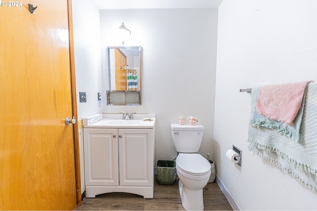 bathroom featuring vanity, toilet, and hardwood / wood-style floors