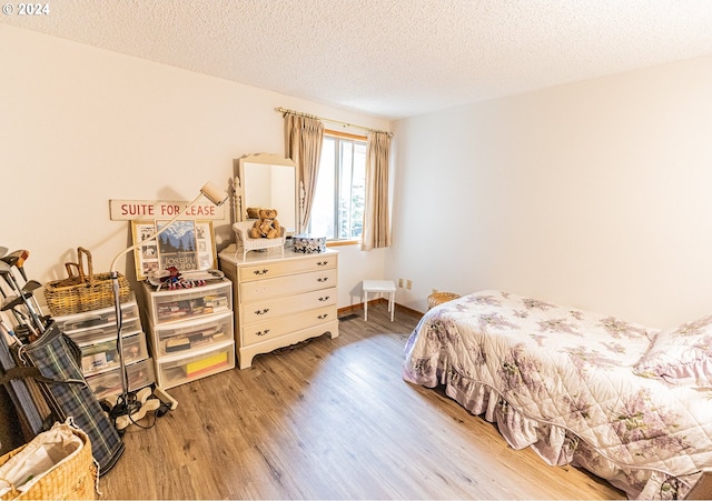 bedroom with a textured ceiling and light wood-type flooring