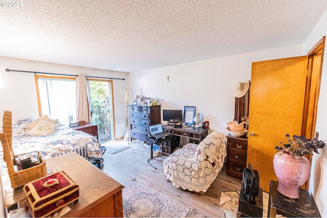 bedroom with hardwood / wood-style floors and a textured ceiling