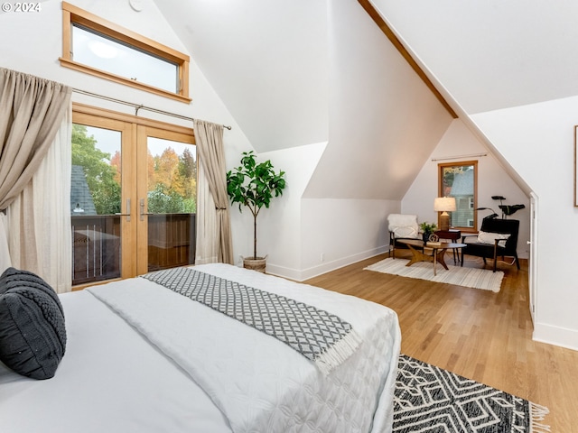 bedroom featuring access to exterior, wood-type flooring, and vaulted ceiling