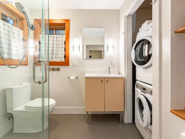 bathroom featuring stacked washer / dryer, vanity, an enclosed shower, and toilet