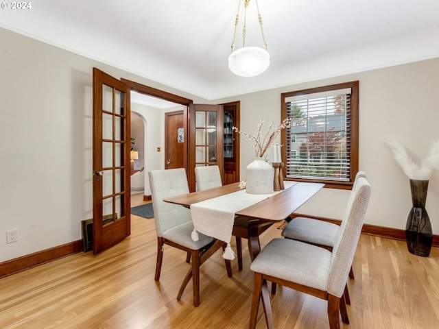 dining space with light hardwood / wood-style floors and french doors