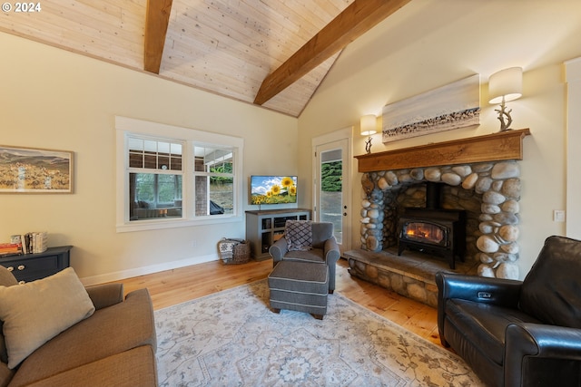 living room featuring light wood-type flooring, a fireplace, a wood stove, wooden ceiling, and lofted ceiling with beams