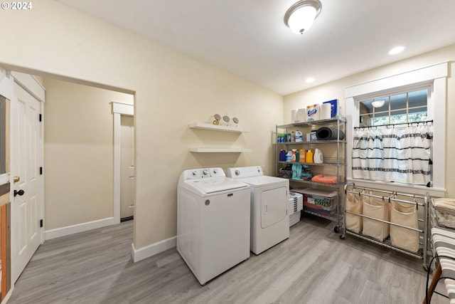 laundry area with light hardwood / wood-style flooring and washer and clothes dryer