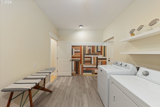 laundry area featuring washing machine and dryer and light hardwood / wood-style floors