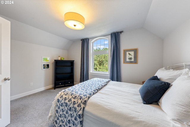 bedroom with vaulted ceiling and light carpet