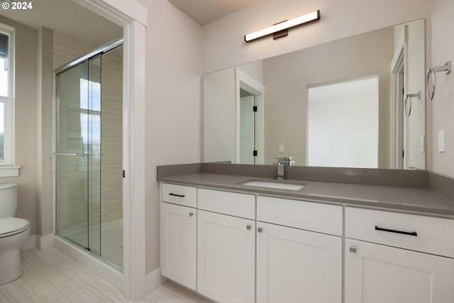 bathroom with an enclosed shower, vanity, and toilet