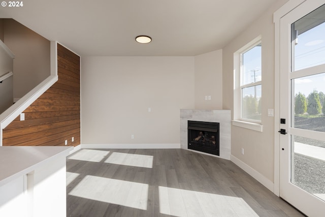 unfurnished living room with a tile fireplace and light hardwood / wood-style flooring