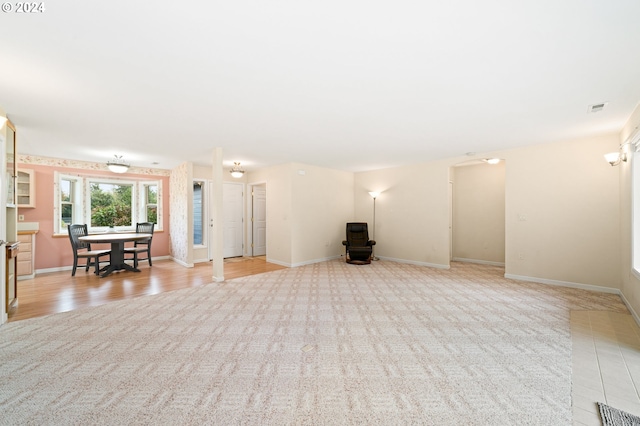 unfurnished living room featuring light carpet