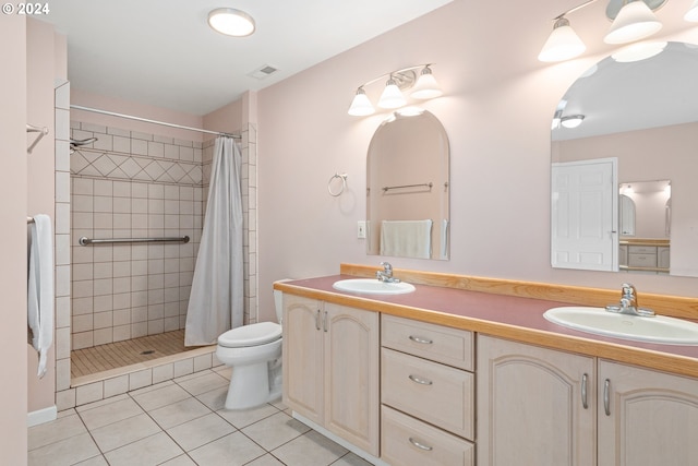 bathroom with toilet, vanity, tile patterned floors, and a shower with shower curtain