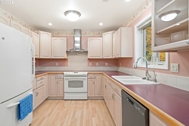 kitchen with wall chimney exhaust hood, sink, white appliances, and light hardwood / wood-style flooring