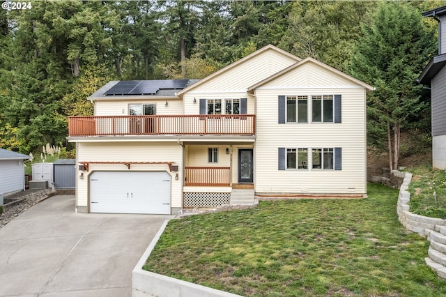 view of front property featuring a balcony, a front yard, solar panels, and a garage