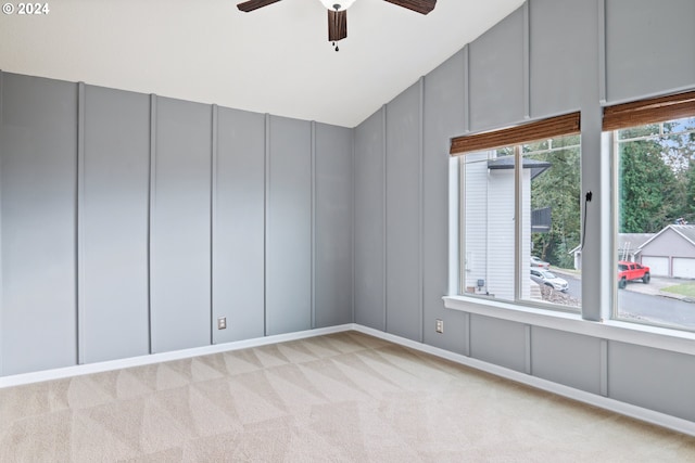 carpeted spare room featuring ceiling fan and vaulted ceiling