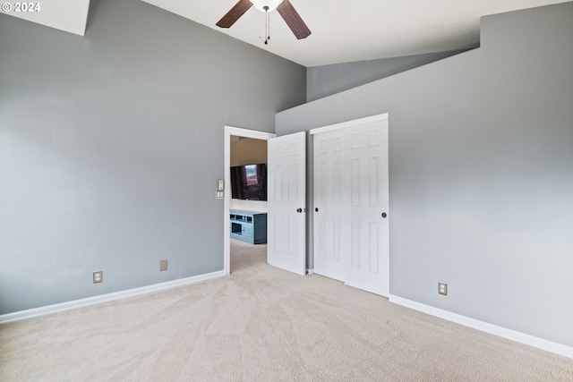 unfurnished bedroom featuring a closet, ceiling fan, high vaulted ceiling, and light colored carpet