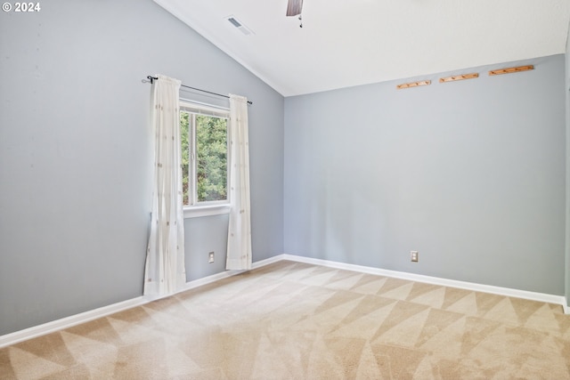 carpeted spare room with ceiling fan and vaulted ceiling