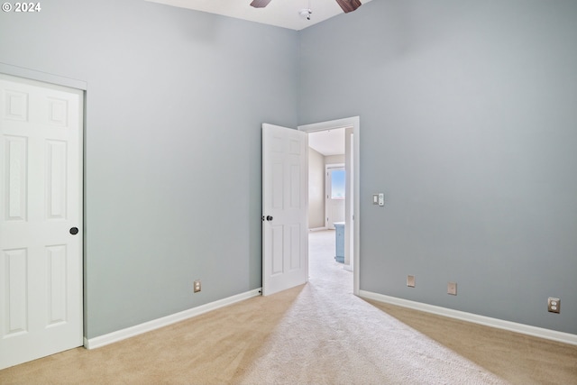 spare room featuring ceiling fan and light colored carpet