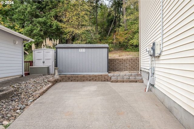 view of patio featuring central air condition unit and a storage unit