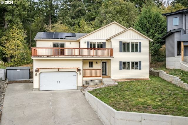 view of front facade featuring solar panels, a front yard, a garage, and a balcony