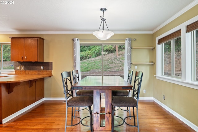 dining area with light hardwood / wood-style flooring and crown molding