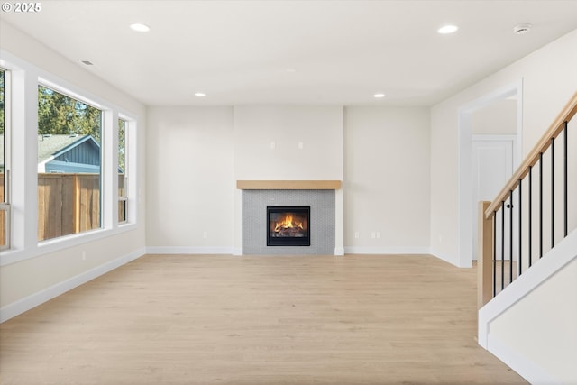 unfurnished living room featuring light hardwood / wood-style flooring and a fireplace