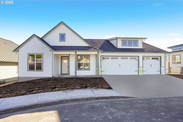 view of front of property with a porch, concrete driveway, a garage, and roof with shingles