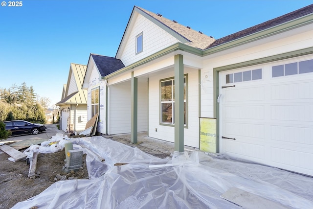 view of front of house with a garage and roof with shingles