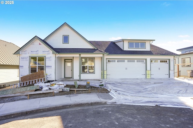 view of front of house featuring a garage, roof with shingles, and concrete driveway