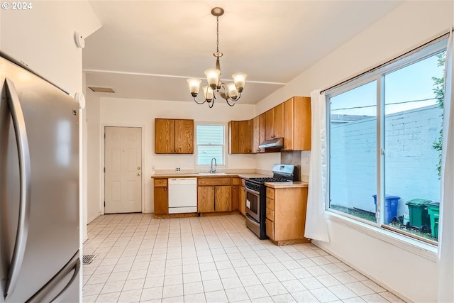 kitchen with a wealth of natural light, light tile floors, appliances with stainless steel finishes, and an inviting chandelier