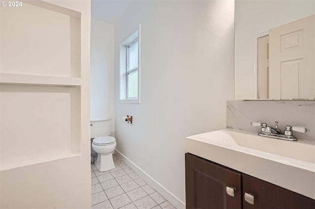 bathroom featuring toilet, vanity, and tile flooring