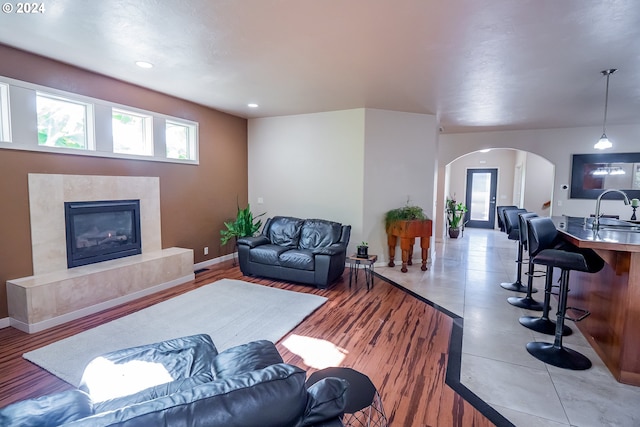 living room featuring tile patterned floors, sink, and a tile fireplace