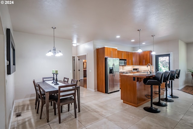 3348 Talon St, Eugene, OR 97408 - kitchen featuring appliances with stainless steel finishes, a sink, a breakfast bar area, brown cabinetry, and visible vents