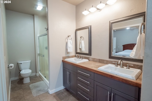 bathroom with toilet, vanity, tile patterned floors, and a shower with door