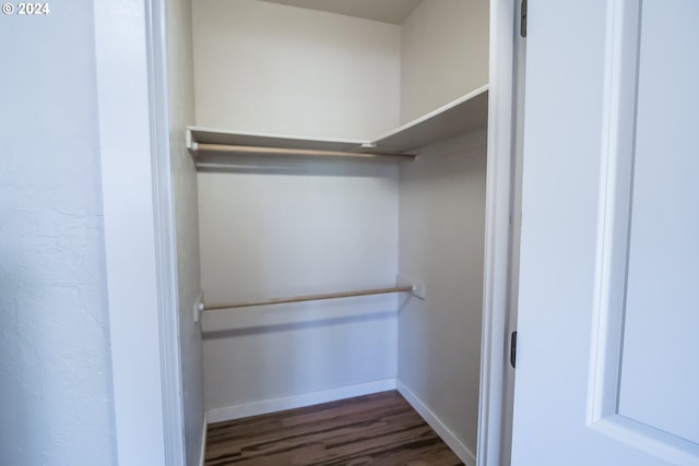 walk in closet with dark hardwood / wood-style floors