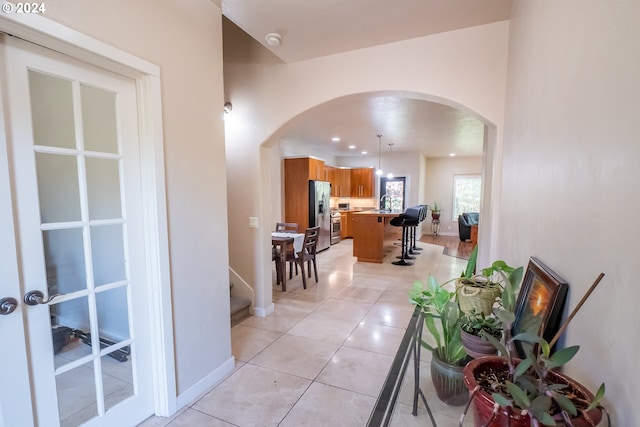 3348 Talon St, Eugene, OR 97408 - corridor featuring baseboards, arched walkways, a sink, and light tile patterned floors